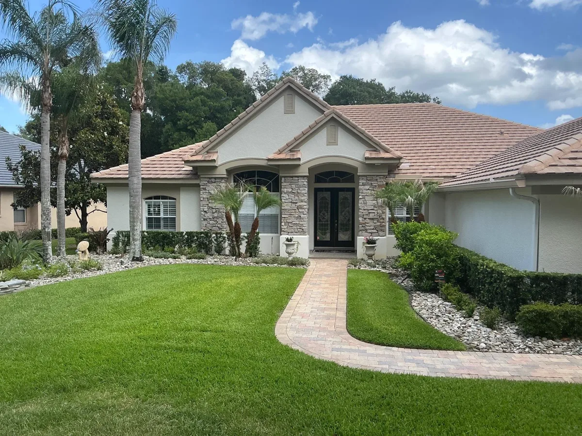 A front yard view of a home with a black double entry door and fresh impact windows.